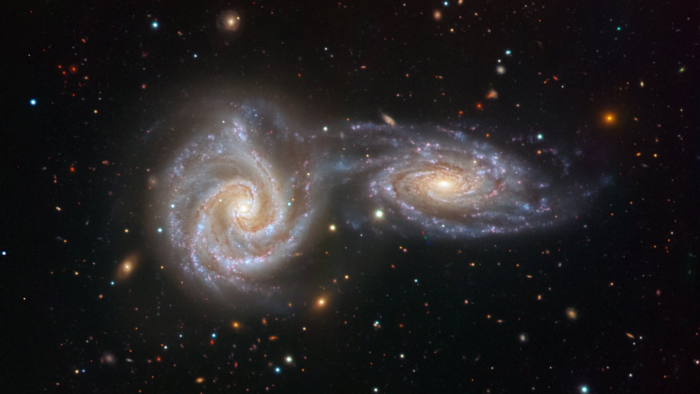 Das Bild zeigt zwei spiralfrömige Strukturen und viele helle Punkte 