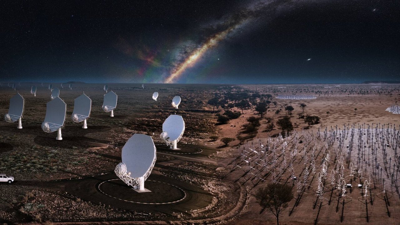 Zahlreiche Radioteleskope und rechts daneben Felder mit vielen Antennen vor dunklem Sternenhimmel