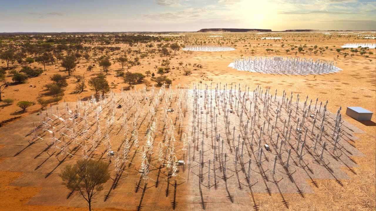 Kreisförmig angeordnete Felder mit hunderten Antennen auf Wüstenuntergrund.