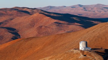 Teleskop auf Bergkuppe in bergiger Wüstenlandschaft