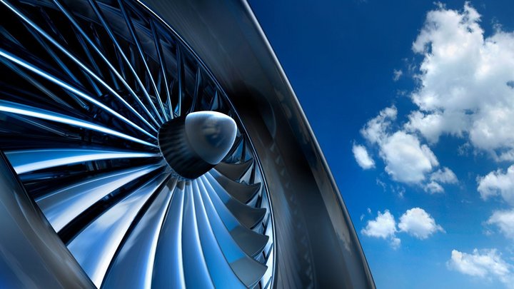 Das Foto zeigt einen Teil einer Flugzeugturbine vor dem Himmel mit Wolken. 