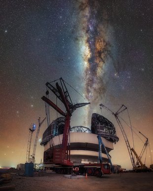 Baustelle mit Baukränen um eine riesige Teleskopkuppel