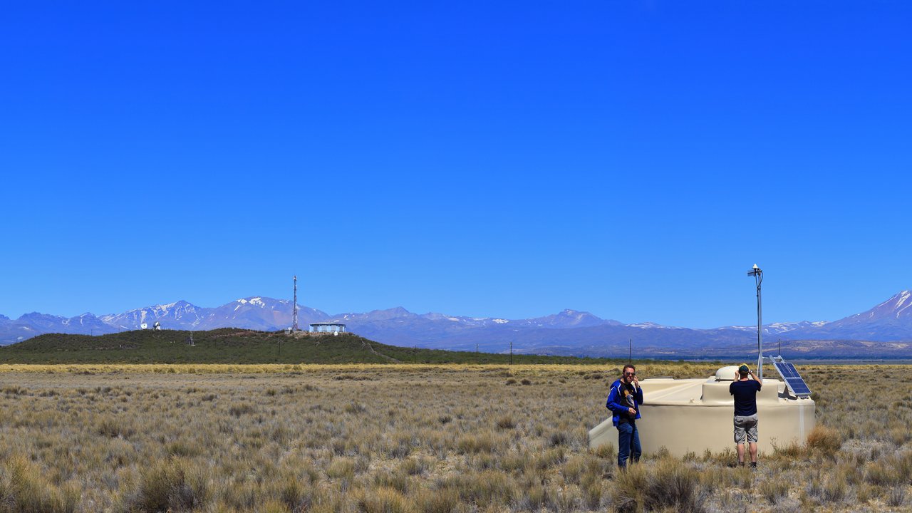 Wüstenlandschaft unter blauem Himmel, rechts ein Wassertank