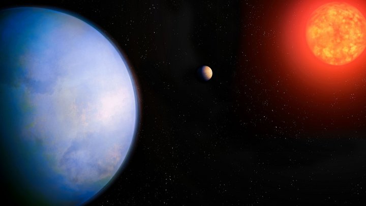 Ein großer blauer Planet im Vordergrund, im Hintergrund ein rot leuchtender Stern, dazwischen ein sehr viel kleinerer brauner Himmelskörper